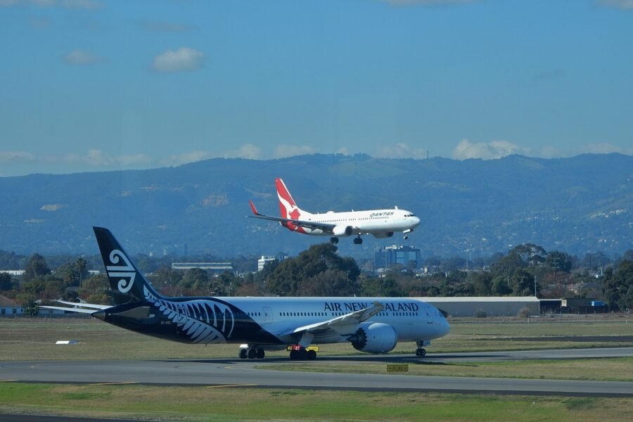 A Qantas 737 lands above an Air New Zealand 787-9 at Adelaide Airport.