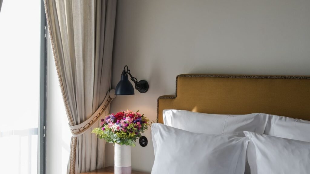Guest room bed and reading lamp at Valverde Lisboa Hotel & Garden